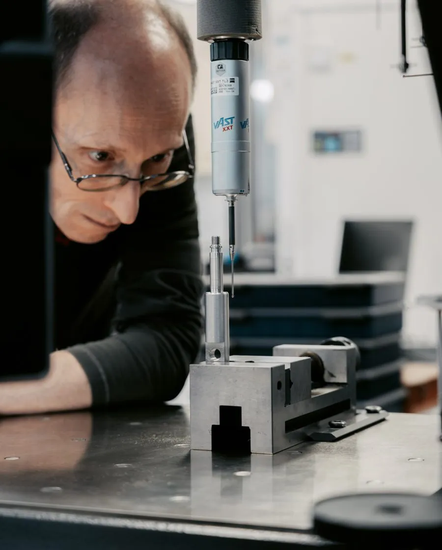 Operator performing dimensional inspection of turned metal parts